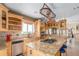 Gourmet kitchen showcases custom wood cabinets, granite countertops, island with cooktop and a view of the yard at 46303 E 106Th Ave, Bennett, CO 80102
