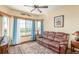 Comfortable living room with plush brown sofa, ceiling fan, and large windows at 46303 E 106Th Ave, Bennett, CO 80102