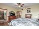 Bedroom featuring wood floors, ceiling fan, backyard views, and an ensuite bathroom at 46303 E 106Th Ave, Bennett, CO 80102