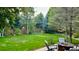 Expansive backyard featuring lush greenery, mature trees, and an inviting outdoor seating area with a fire pit at 11321 Mesa Verde Pl, Parker, CO 80138