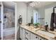 Well-lit bathroom with double sinks, granite countertops and a view of a tub and shower at 11321 Mesa Verde Pl, Parker, CO 80138