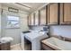Bright laundry room featuring cabinetry above front load washer and dryer with wash sink and ample counter space at 11321 Mesa Verde Pl, Parker, CO 80138