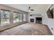 Bright living room featuring large windows, a fireplace with a mantel, and plush carpeting at 11321 Mesa Verde Pl, Parker, CO 80138