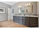 Bathroom with granite countertop, double sinks, dark grey cabinets, and tiled floor at 13084 Deer Ridge Way, Larkspur, CO 80118