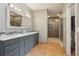 Luxurious bathroom features double sinks, tile floors, and walk-in closet access at 13084 Deer Ridge Way, Larkspur, CO 80118