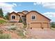 Stunning stucco home featuring a three-car garage and beautiful rock landscaping at 13084 Deer Ridge Way, Larkspur, CO 80118