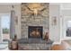 Close-up of a stone fireplace featuring decor elements, a slate hearth, and a cozy fire at 13084 Deer Ridge Way, Larkspur, CO 80118