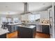 Open concept kitchen features a central island, stainless appliances, and seamless flow to the dining area at 13084 Deer Ridge Way, Larkspur, CO 80118