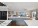Open concept kitchen with a large center island and seamless transition into the living room at 13084 Deer Ridge Way, Larkspur, CO 80118