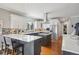 Bright kitchen features white cabinets, stainless appliances, hardwood floors, and a center island cooktop at 13084 Deer Ridge Way, Larkspur, CO 80118