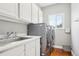 Efficient laundry room with sink, counter space, and modern washer and dryer at 13084 Deer Ridge Way, Larkspur, CO 80118