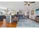 Bright living area open to the kitchen featuring hardwood floors, a comfortable sofa, and a ceiling fan at 13084 Deer Ridge Way, Larkspur, CO 80118