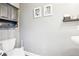 Powder room view featuring a toilet, wall art and decorative shelf and a view to a stand sink at 13084 Deer Ridge Way, Larkspur, CO 80118