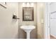 Charming powder room featuring a pedestal sink, decorative mirror, and modern lighting at 13084 Deer Ridge Way, Larkspur, CO 80118