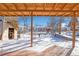 Covered patio overlooks a spacious backyard with snow-covered ground at 2220 S Linley Ct, Denver, CO 80219