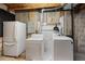 Unfinished basement features a washing machine, dryer, and refrigerator with open ceiling at 2550 S Cutters Cir # 105, Castle Rock, CO 80108
