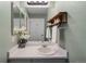 Well-lit bathroom with a sink, decorative shelves, a large mirror, and white walls at 2550 S Cutters Cir # 105, Castle Rock, CO 80108