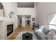 Open-concept living room with a fireplace, hardwood floors, and view into the kitchen at 2550 S Cutters Cir # 105, Castle Rock, CO 80108