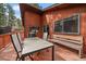 Back deck with table and chair set and wooden bench, as well as trees in the background at 28630 Pine Dr, Evergreen, CO 80439