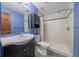 Bathroom featuring a tile shower, a vanity sink, and blue walls at 28630 Pine Dr, Evergreen, CO 80439