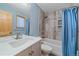 Bathroom featuring blue walls, a modern vanity, toilet, and a shower/tub with decorative tile and a blue curtain at 28630 Pine Dr, Evergreen, CO 80439