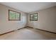 Bright bedroom featuring neutral walls, carpet, and two windows with wood trim, offering natural light and views at 28630 Pine Dr, Evergreen, CO 80439