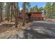 Exterior of the home with driveway, two-car garage, and wood siding amongst mature trees at 28630 Pine Dr, Evergreen, CO 80439