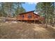 Exterior view of elevated house featuring a large deck and surrounding trees at 28630 Pine Dr, Evergreen, CO 80439