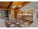 Bright living space with a wood-paneled ceiling, brick fireplace, and combined kitchen area at 28630 Pine Dr, Evergreen, CO 80439