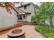 Backyard patio with fire pit, flowering plants, trees, and access to the house at 7409 E Jamison Dr, Centennial, CO 80112