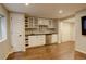 Basement wet bar with stainless steel mini fridge, dark countertops, wine rack, and wooden floors at 7409 E Jamison Dr, Centennial, CO 80112