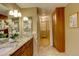 Bathroom boasts dual sinks with granite counters, wood cabinets and convenient access to the closet at 7409 E Jamison Dr, Centennial, CO 80112