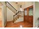 Elegant foyer with hardwood floors, staircase with black wrought iron railing and glass paneled front door at 7409 E Jamison Dr, Centennial, CO 80112