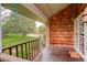 Charming front porch with wood decking, railing, and views of the lush green lawn and trees at 7409 E Jamison Dr, Centennial, CO 80112