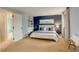 Spacious main bedroom with an en-suite bathroom, blue accent wall, and plush carpet at 7409 E Jamison Dr, Centennial, CO 80112