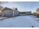 Spacious backyard with a snow-covered lawn, gray house, and wooden fence at 4770 S Jason St, Englewood, CO 80110