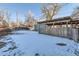 Backyard with pergola, wooden fence, and snow-covered lawn at 4770 S Jason St, Englewood, CO 80110