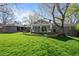 Expansive backyard with green lawn, mature trees, and a sunroom perfect for outdoor living at 4951 Sanford W Cir, Cherry Hills Village, CO 80113