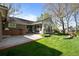 A well-maintained backyard with a brick patio and a sunroom addition to the house at 4951 Sanford W Cir, Cherry Hills Village, CO 80113