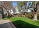 Lush backyard features mature trees, a well-manicured lawn, and a charming waterfall at 4951 Sanford W Cir, Cherry Hills Village, CO 80113