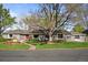 Charming ranch style home featuring a well-manicured lawn, mature trees, and a red front door at 4951 Sanford W Cir, Cherry Hills Village, CO 80113