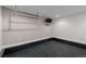 Clean garage with black flooring, storage rack and mounted TV at 4951 Sanford W Cir, Cherry Hills Village, CO 80113