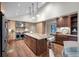 Gourmet kitchen featuring high-end appliances, a large island with seating, and custom wood cabinetry at 4951 Sanford W Cir, Cherry Hills Village, CO 80113