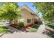 Exterior view of the townhome with landscaping and a walkway at 9026 E Mansfield Ave, Denver, CO 80237