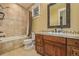 A well-lit bathroom with earth tone tile, a shower/tub combo and dark wood vanity at 14154 Lexington Cir, Westminster, CO 80023