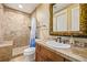 A cozy bathroom with a shower/tub combo, earth tone tile and a dark wood vanity at 14154 Lexington Cir, Westminster, CO 80023