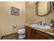 Elegant powder room with a decorative mirror, granite countertop, and a wall-mounted floral artwork at 14154 Lexington Cir, Westminster, CO 80023