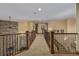 Spacious upstairs hallway with stone accent wall, carpet flooring, and iron railing overlooking the lower level at 14154 Lexington Cir, Westminster, CO 80023