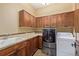A well-equipped laundry room featuring ample cabinetry, counter space, and modern washer/dryer units at 14154 Lexington Cir, Westminster, CO 80023