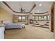 Large bedroom featuring a sitting area with a fireplace, tray ceilings, and multiple windows for ample natural light at 14154 Lexington Cir, Westminster, CO 80023